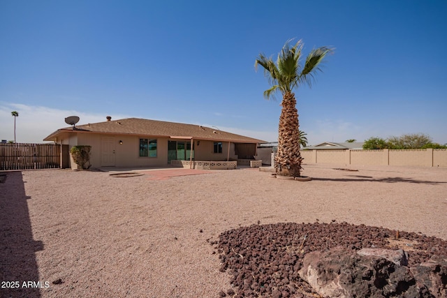 rear view of property featuring a patio area, a fenced backyard, and stucco siding