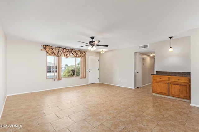 spare room with visible vents, ceiling fan, baseboards, and light tile patterned floors