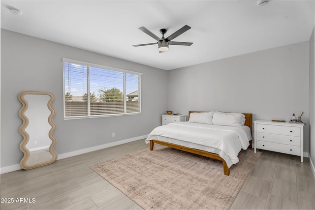 bedroom featuring baseboards, light wood-style floors, and ceiling fan