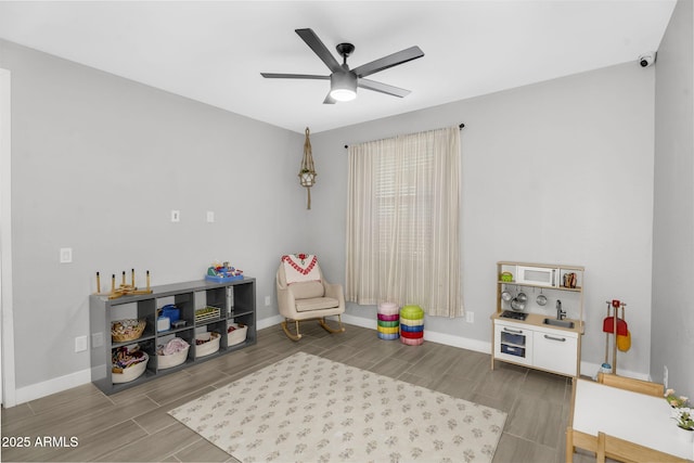 game room featuring a ceiling fan, baseboards, and wood finish floors