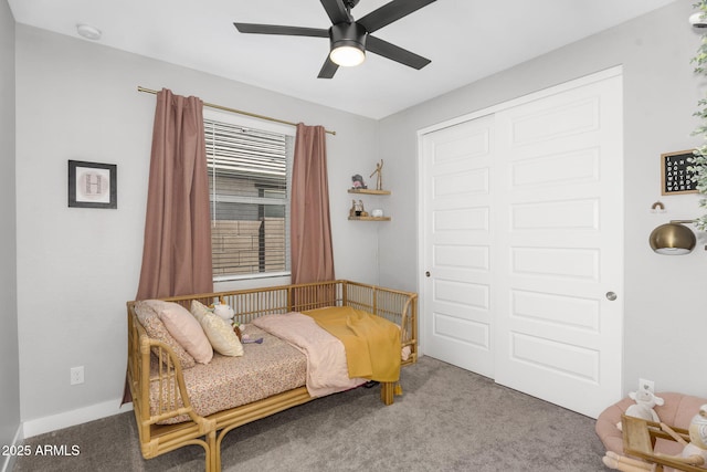carpeted bedroom featuring ceiling fan and a closet