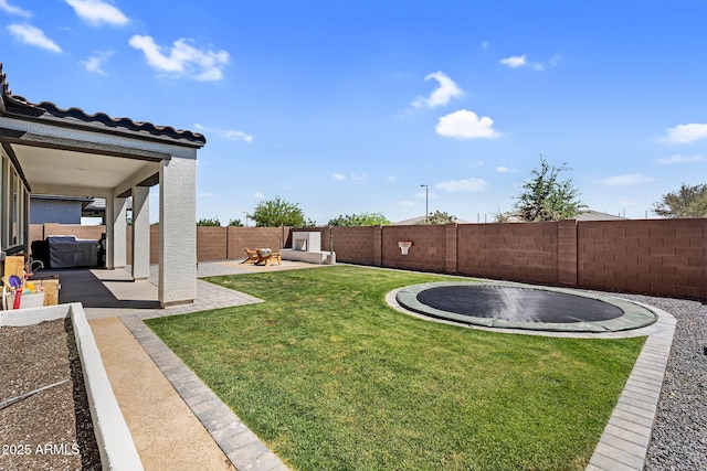 view of yard with a fenced backyard, a patio area, and a trampoline