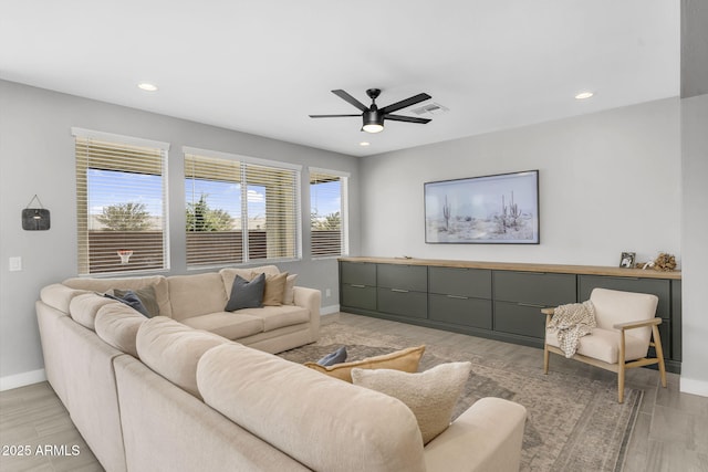 living area featuring visible vents, baseboards, recessed lighting, and ceiling fan