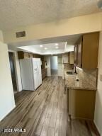 kitchen featuring sink, light stone counters, dark hardwood / wood-style flooring, and kitchen peninsula