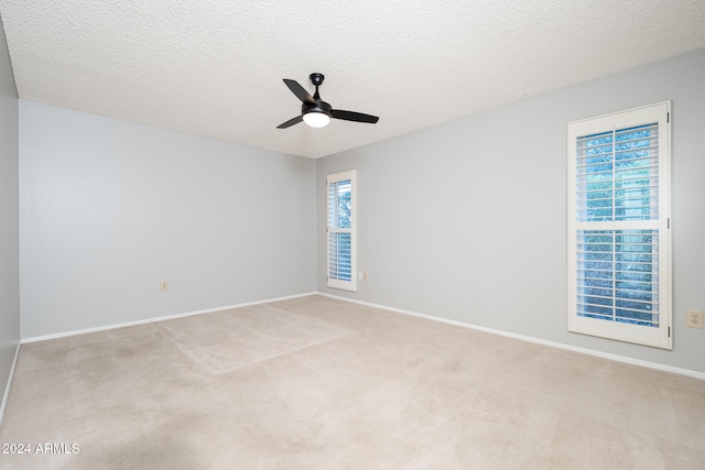 carpeted empty room featuring a textured ceiling and ceiling fan