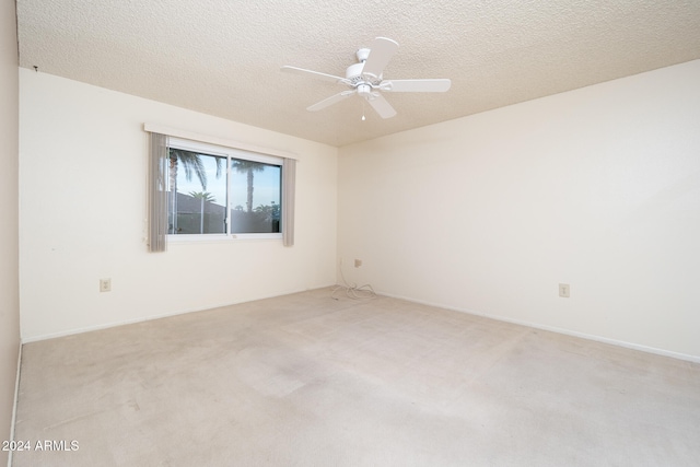 spare room featuring a textured ceiling, light colored carpet, and ceiling fan