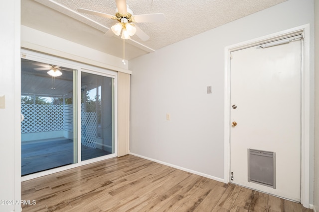 empty room with a textured ceiling, hardwood / wood-style flooring, and ceiling fan