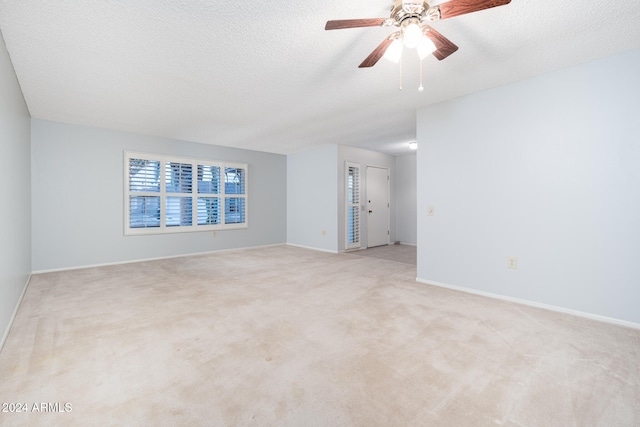 empty room featuring light carpet, a textured ceiling, and ceiling fan