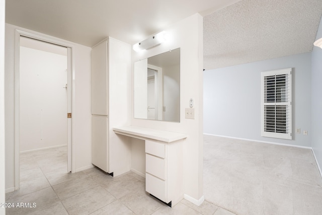 bathroom featuring a textured ceiling and tile patterned flooring