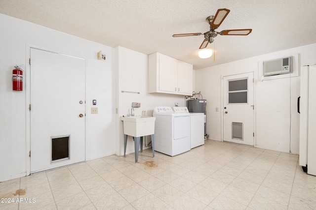 laundry area featuring washer and dryer, a wall mounted air conditioner, a textured ceiling, ceiling fan, and cabinets