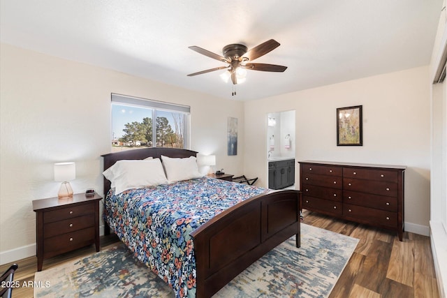11421 W Lakeshore Dr, Youngtown, AZ 85363 - bedroom featuring baseboards, wood finished floors, ceiling fan, and ensuite bathroom
