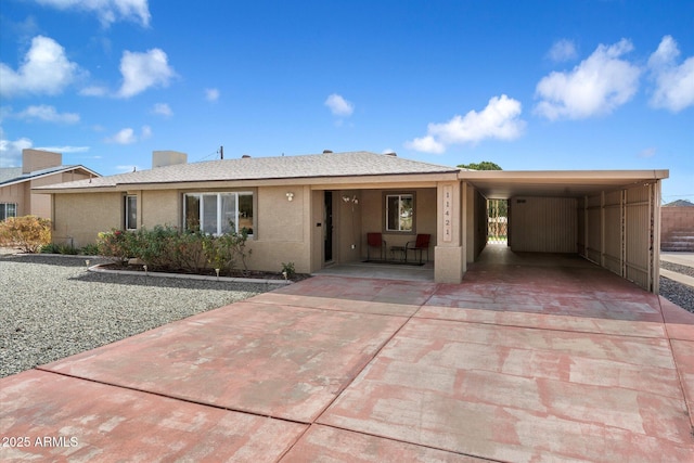 11421 W Lakeshore Dr, Youngtown, AZ 85363 - view of front of property featuring stucco siding, driveway, a carport, and roof with shingles