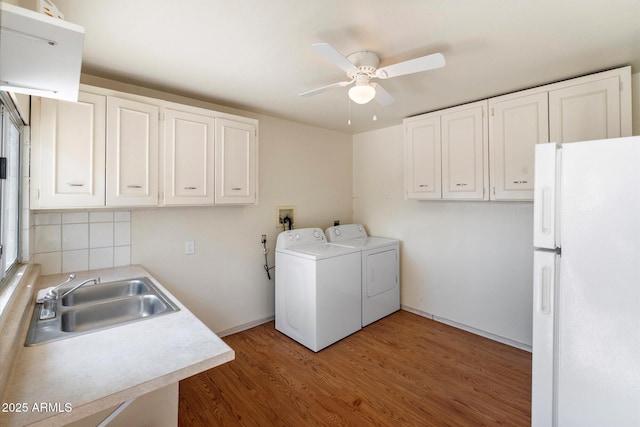 11421 W Lakeshore Dr, Youngtown, AZ 85363 - clothes washing area with washer and clothes dryer, a sink, ceiling fan, laundry area, and wood finished floors