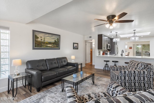11421 W Lakeshore Dr, Youngtown, AZ 85363 - living room with baseboards, a wealth of natural light, wood finished floors, and a ceiling fan