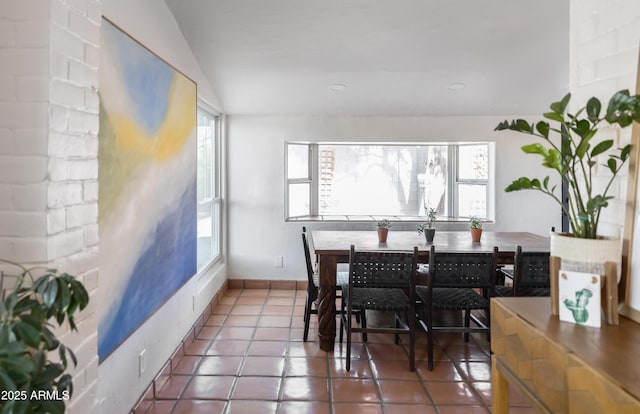 dining area with tile patterned flooring, lofted ceiling, and plenty of natural light