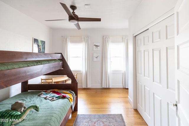 bedroom featuring ceiling fan, light hardwood / wood-style floors, and a closet