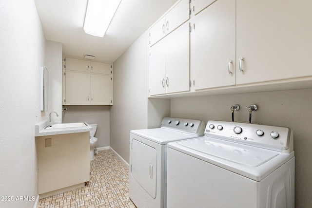 washroom featuring a sink, laundry area, baseboards, and washer and clothes dryer