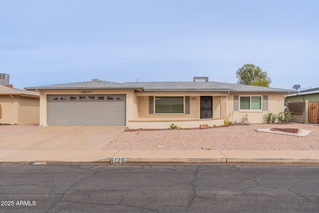 single story home featuring stucco siding, concrete driveway, an attached garage, and fence