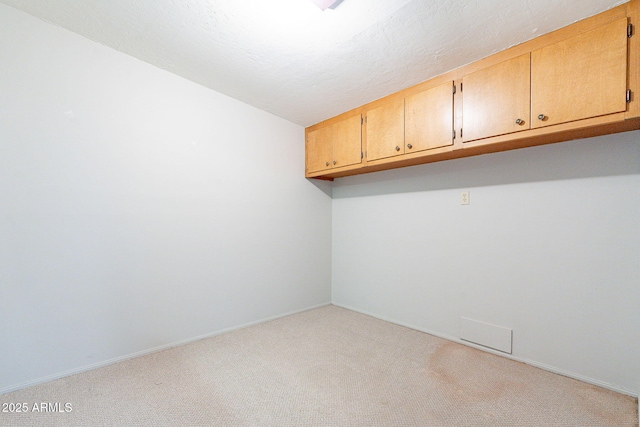 carpeted empty room featuring baseboards and a textured ceiling