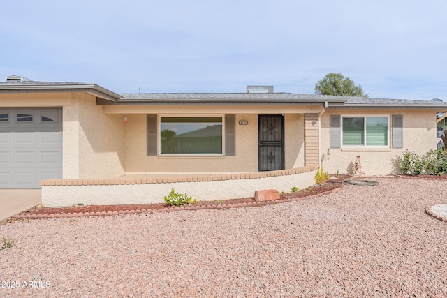 ranch-style home with stucco siding, roof with shingles, concrete driveway, and an attached garage