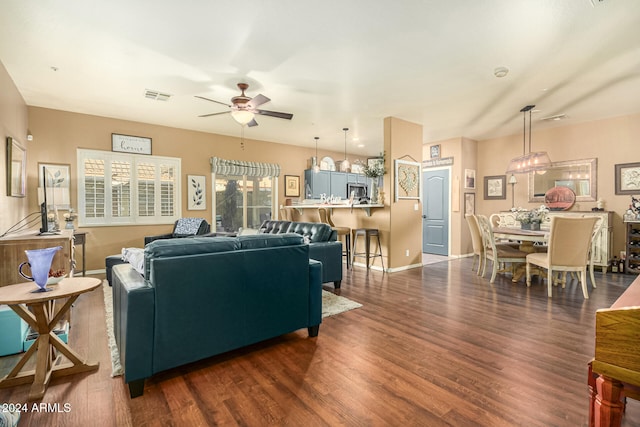 living room with ceiling fan and dark wood-type flooring