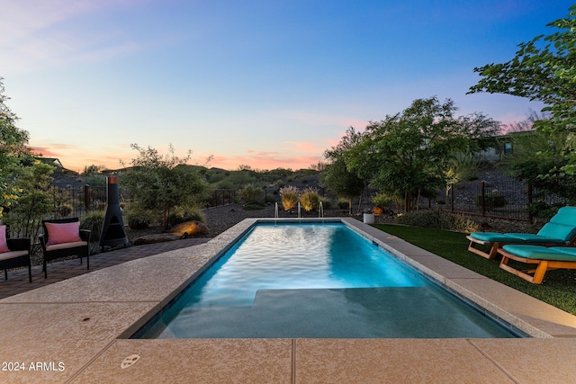 pool at dusk with a patio