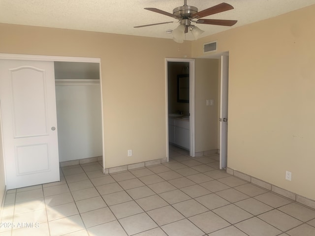 unfurnished bedroom featuring visible vents, ceiling fan, light tile patterned floors, a closet, and a textured ceiling