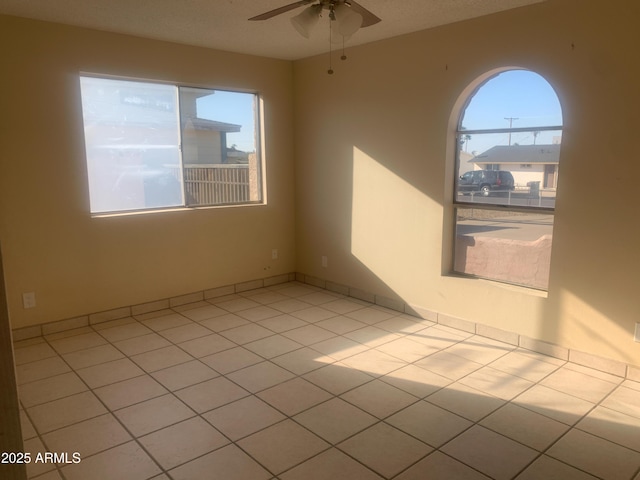 unfurnished room featuring light tile patterned floors and ceiling fan