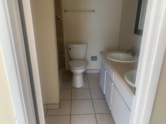 full bath featuring tile patterned flooring, baseboards, toilet, double vanity, and a sink