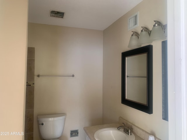 bathroom featuring visible vents, toilet, and vanity