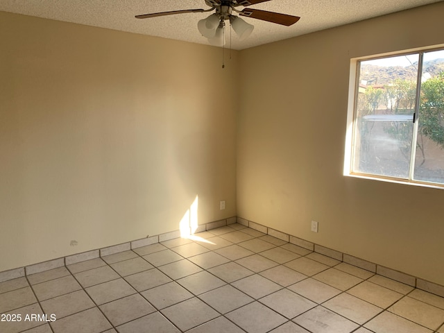 unfurnished room with light tile patterned floors, a ceiling fan, and a textured ceiling