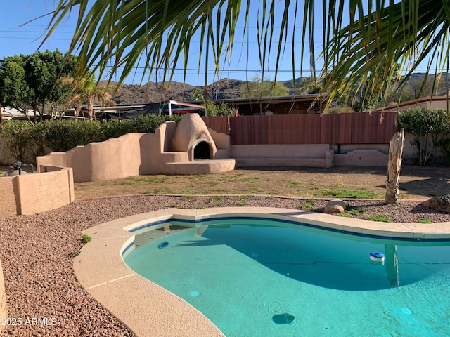 view of swimming pool featuring fence and a mountain view