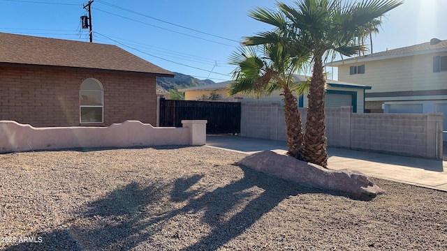 view of yard with concrete driveway and fence