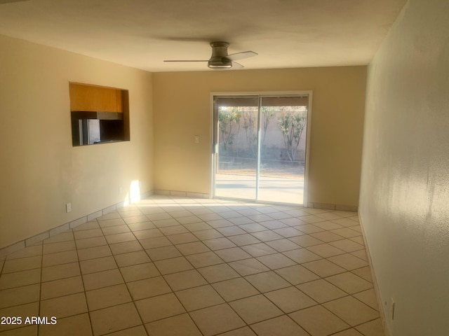 unfurnished room featuring light tile patterned floors, baseboards, and a ceiling fan