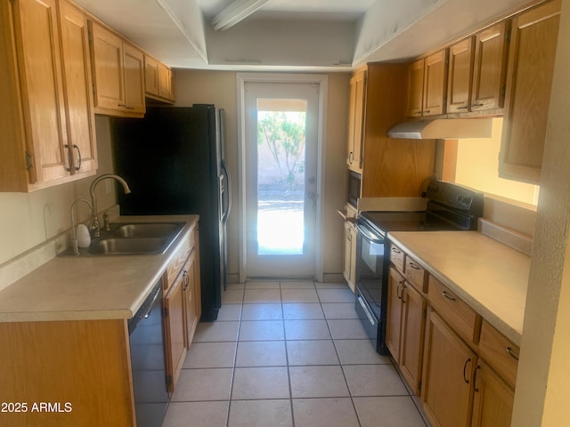 kitchen featuring light tile patterned flooring, a sink, black appliances, light countertops, and under cabinet range hood