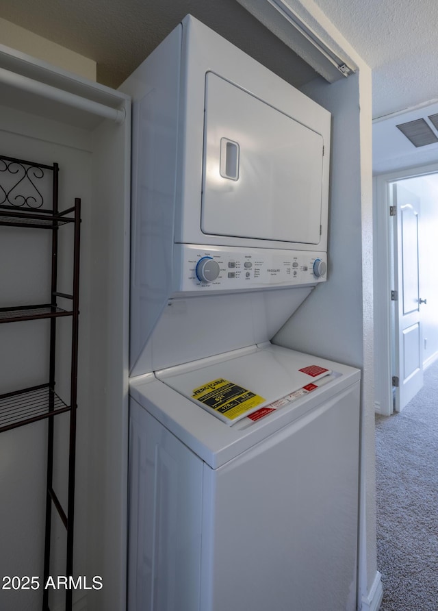 3330 W Danbury Dr Unit E203, Phoenix, AZ 85053 - washroom featuring stacked washer and clothes dryer and carpet flooring