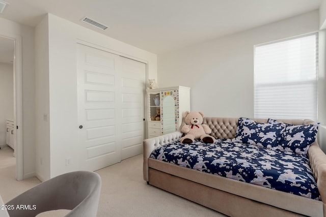 bedroom featuring light carpet and a closet