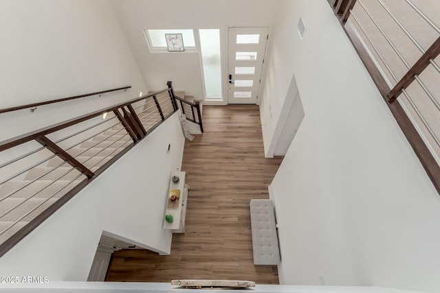 stairs featuring a high ceiling and hardwood / wood-style flooring