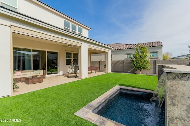 back of property with outdoor lounge area, ceiling fan, a patio area, and a yard