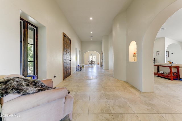 hall with recessed lighting and arched walkways