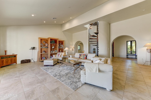 living area with recessed lighting, arched walkways, and high vaulted ceiling