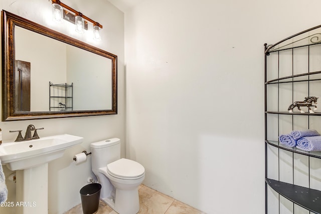 bathroom featuring tile patterned floors, toilet, and a sink