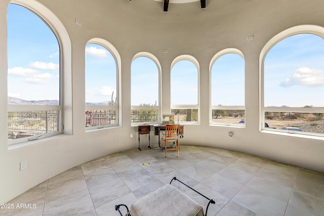 unfurnished sunroom featuring a mountain view