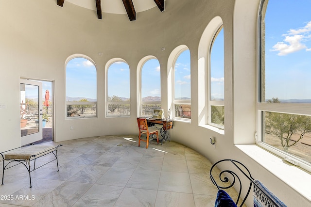 unfurnished sunroom featuring beamed ceiling