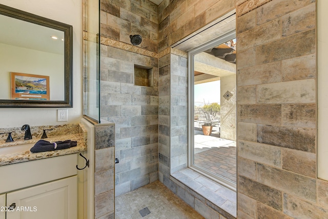 bathroom with vanity and tiled shower