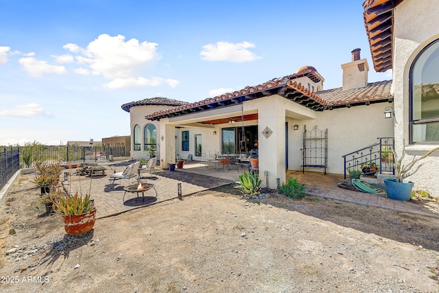 view of patio / terrace with a fire pit, a ceiling fan, and fence