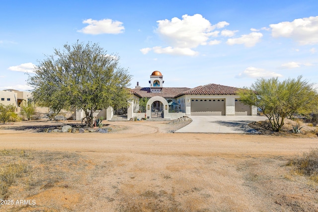 mediterranean / spanish-style house featuring a tiled roof, an attached garage, driveway, and stucco siding