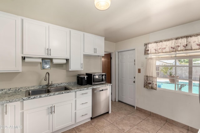 3617 W Luke Ave, Phoenix, AZ 85019 - kitchen with light tile patterned flooring, white cabinets, light stone counters, a sink, and stainless steel appliances