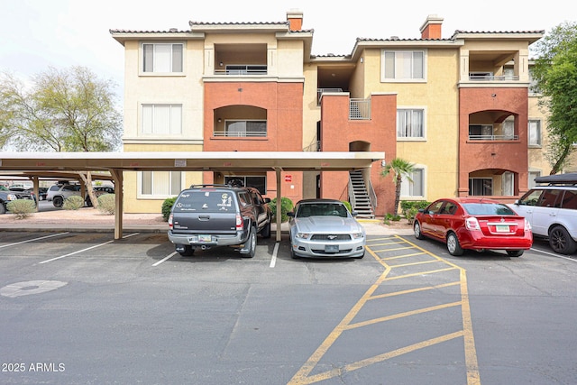 view of property with covered and uncovered parking