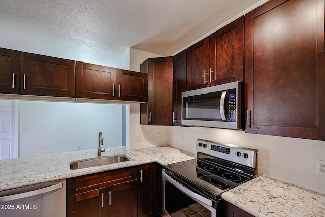 5401 E Van Buren St Unit 2095, Phoenix, AZ 85008 - kitchen with dark brown cabinets, light stone counters, stainless steel appliances, and a sink